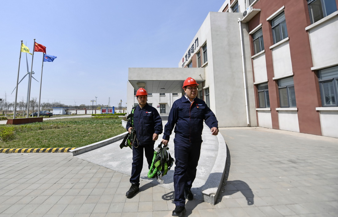 劉彥波（右）和同事胡眾銀准備乘車前往一風電機組進行檢修作業（4月13日攝）。