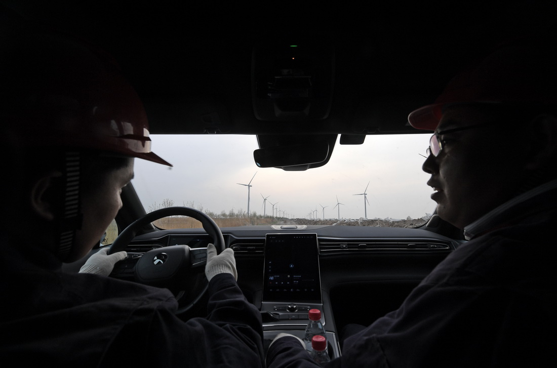 劉彥波（右）和同事胡眾銀乘車前往一風電機組進行檢修作業（4月12日攝）。