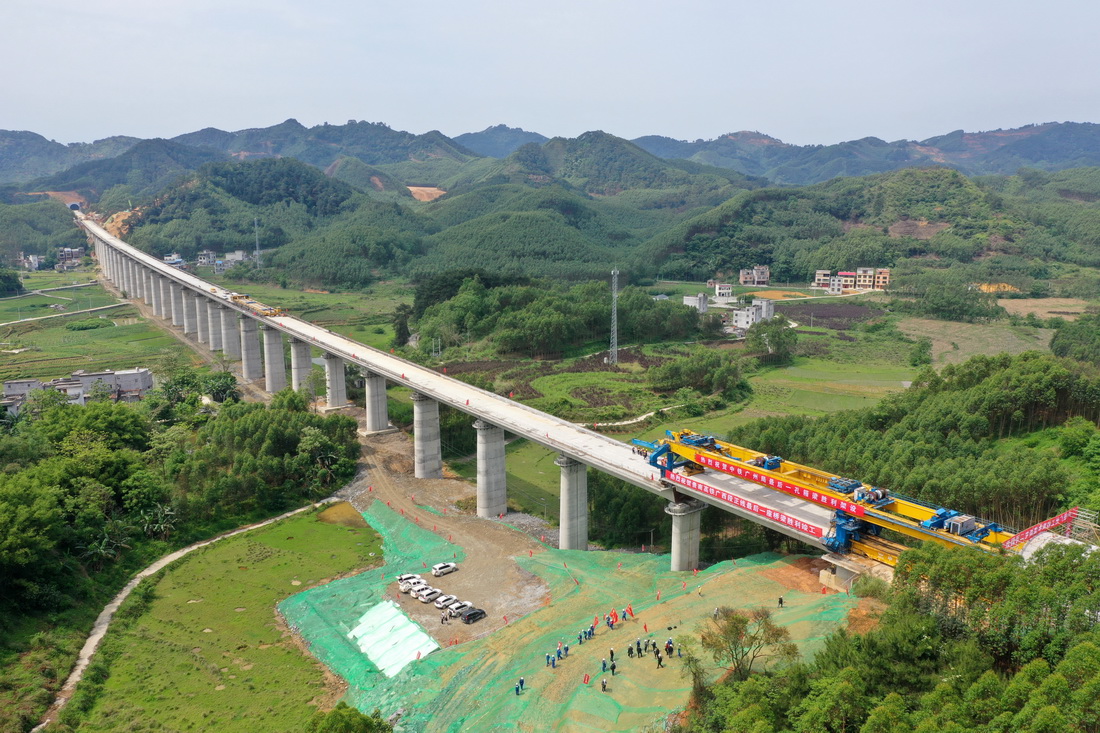 4月19日，在贵南高铁位升双线特大桥建设现场，中铁广州工程局工人在最后一榀箱梁架设施工中（无人机照片）。