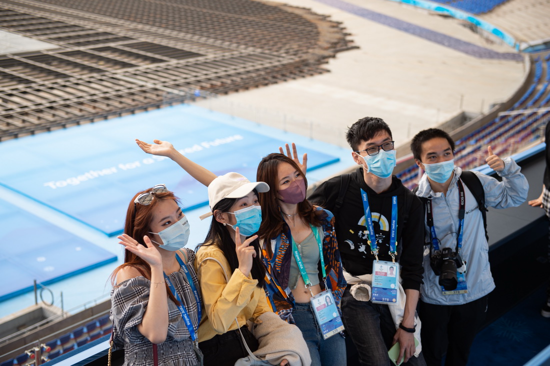 4月20日，受邀体验“双奥”主题旅游线路的北京冬奥会开闭幕式志愿者在主席台区域留影。