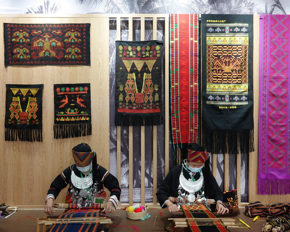 4月21日，黎族妇女在“寻觅雨林・万物共生”热带雨林文化展上展示织黎锦。新华社记者 丁洪法 摄