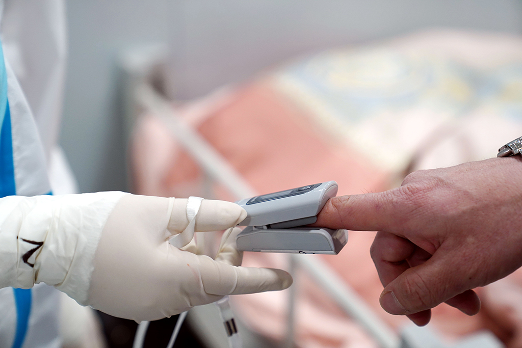 4月21日，临港方舱医院的医护人员帮患者测量血氧饱和度。