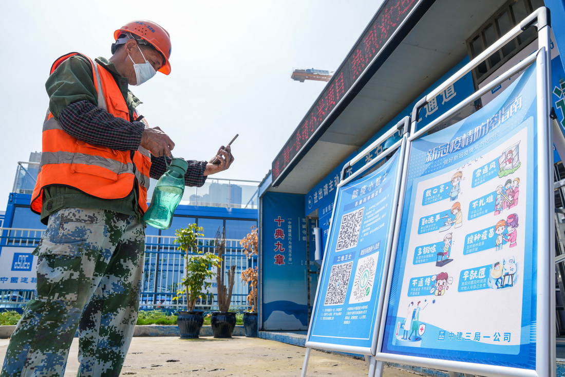 4月24日，中建三局一公司的工程人員在進入施工現場前，用手機掃碼登記信息。