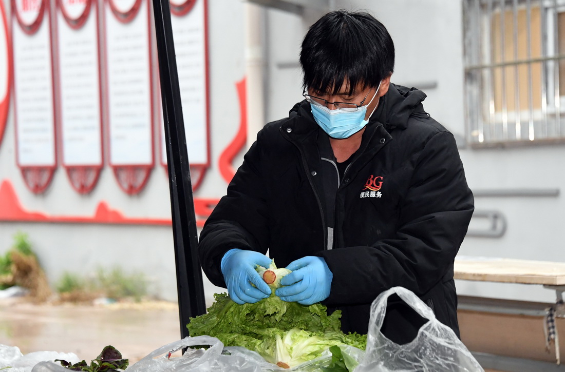 4月27日，在北京市海淀区北下关街道蔬菜直通车皂君西里社区站点，工作人员在码放蔬菜。