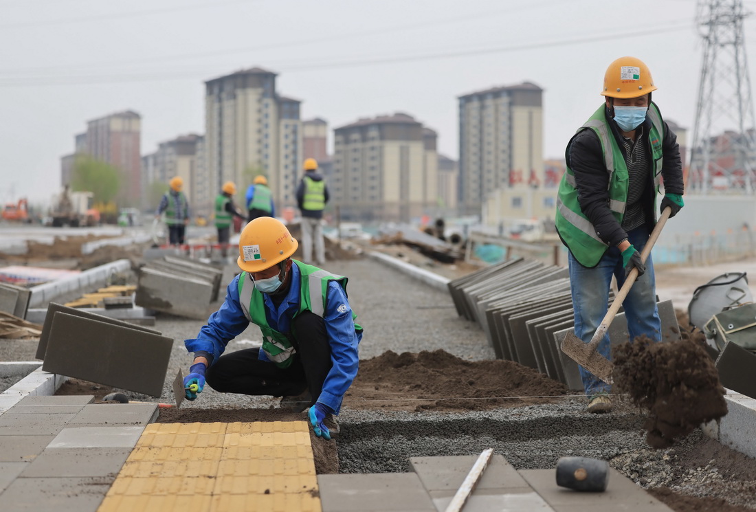 4月28日，中鐵十一局的工人在雄安新區容西片區奧威路施工。