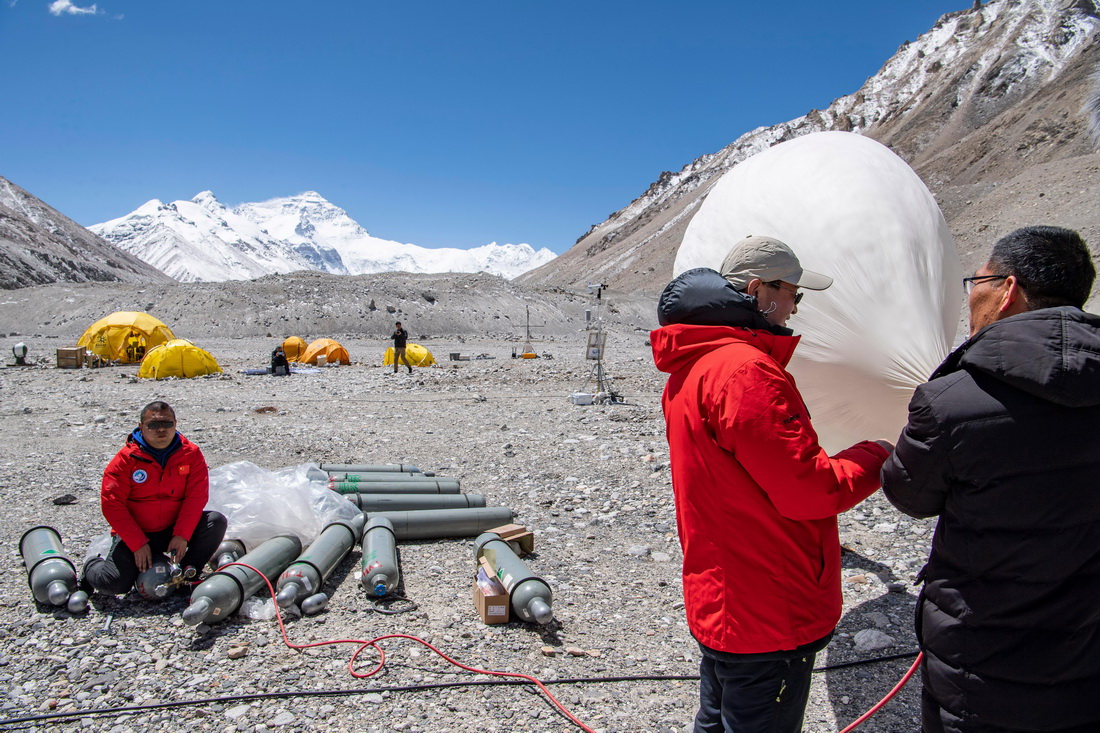 在珠峰登山大本營，科研人員給大氣臭氧探空氣球充氣（5月3日攝）。新華社記者 孫非 攝