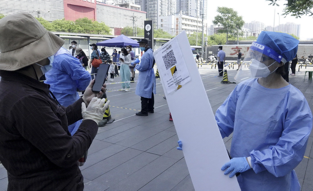 5月4日，北京朝阳区八里庄街道的青年志愿者指导市民进行核酸检测前的扫码登记。
