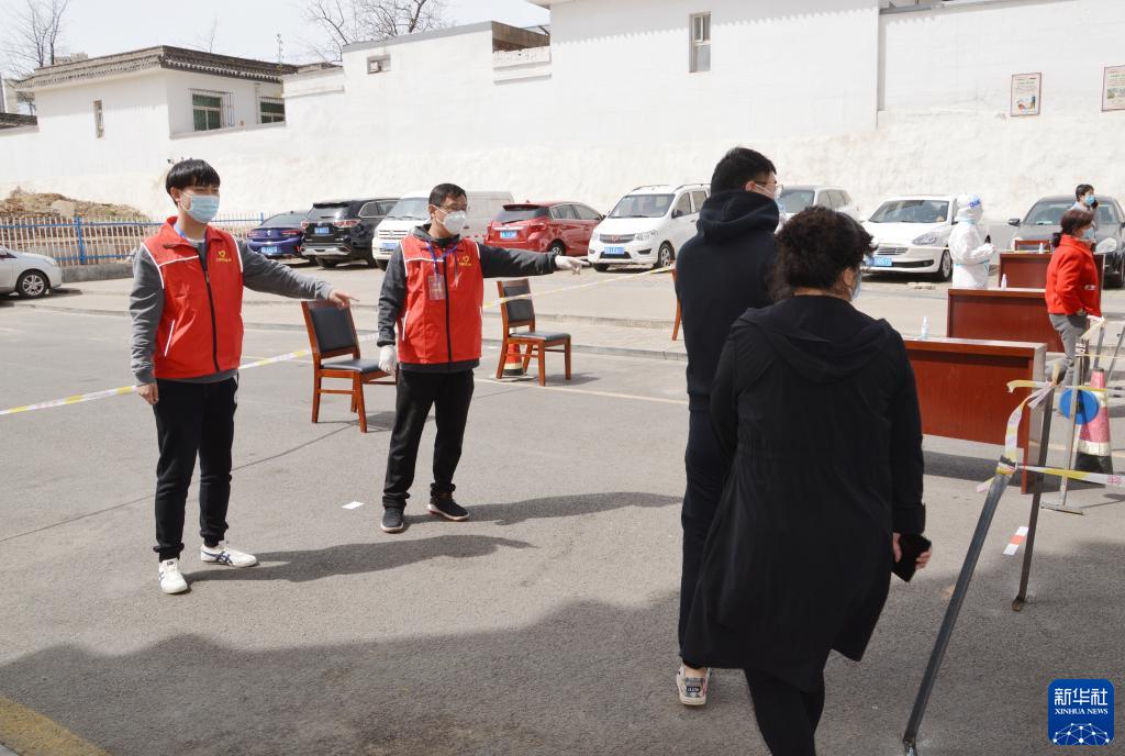 方昱淋（左一）在太原市万柏林区白家庄街道桃杏村引导村民有序进行核酸检测（4月12日手机拍摄）。新华社发