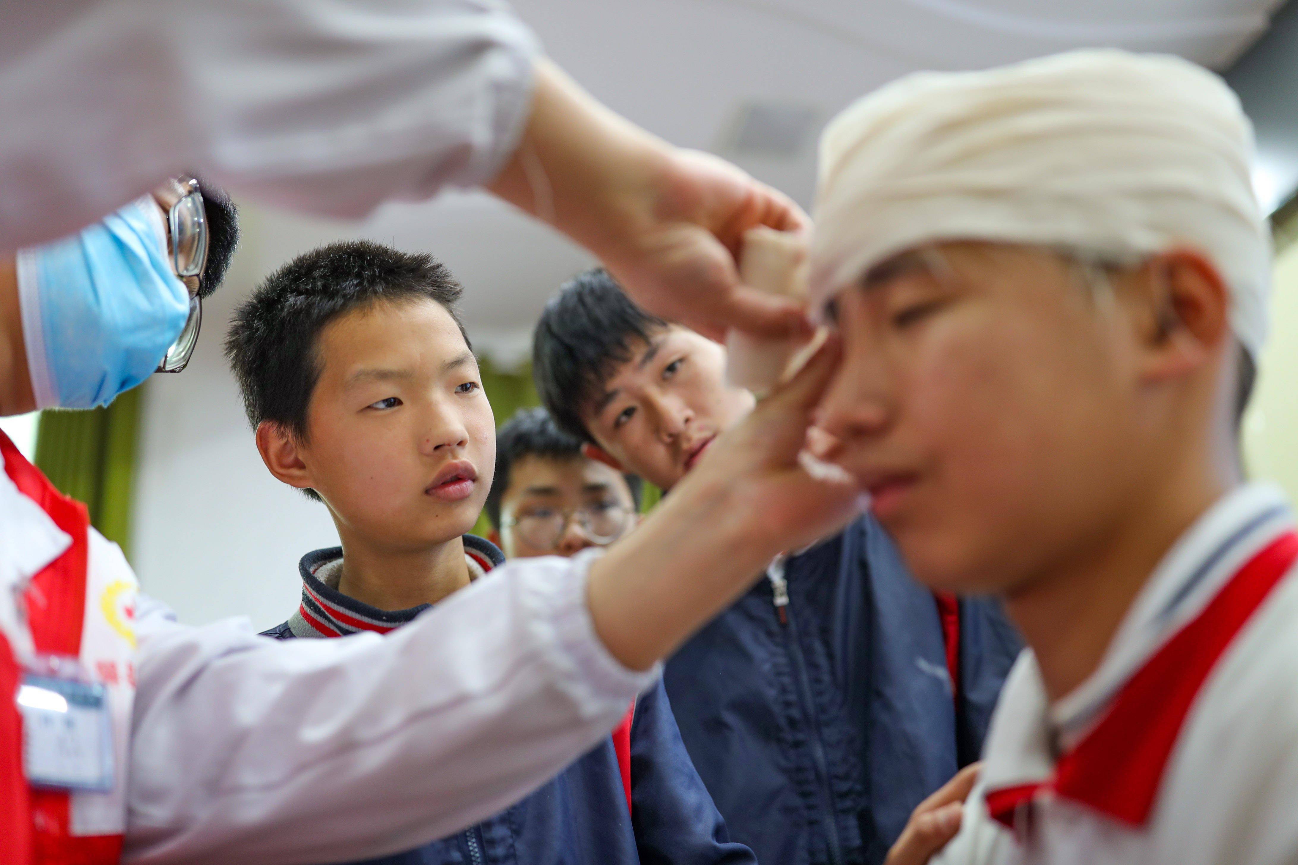 5月7日，贵州省铜仁市玉屏侗族自治县红十字会志愿者给学生讲解创伤包扎技术。新华社发（胡攀学 摄）