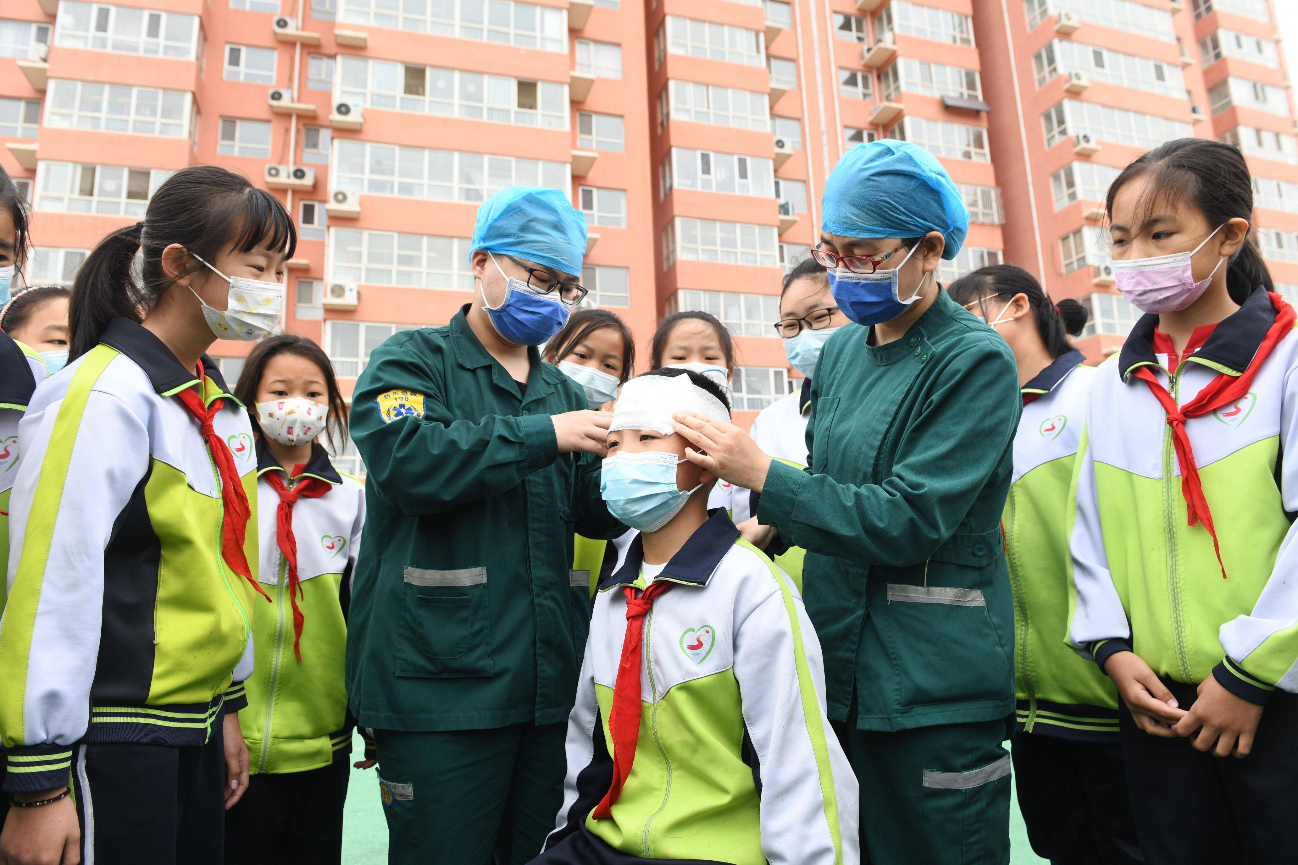 5月7日，在河北省石家庄新乐市民生街小学，新乐市中医院医护人员向学生讲解急救包扎知识。新华社发（贾敏杰 摄）
