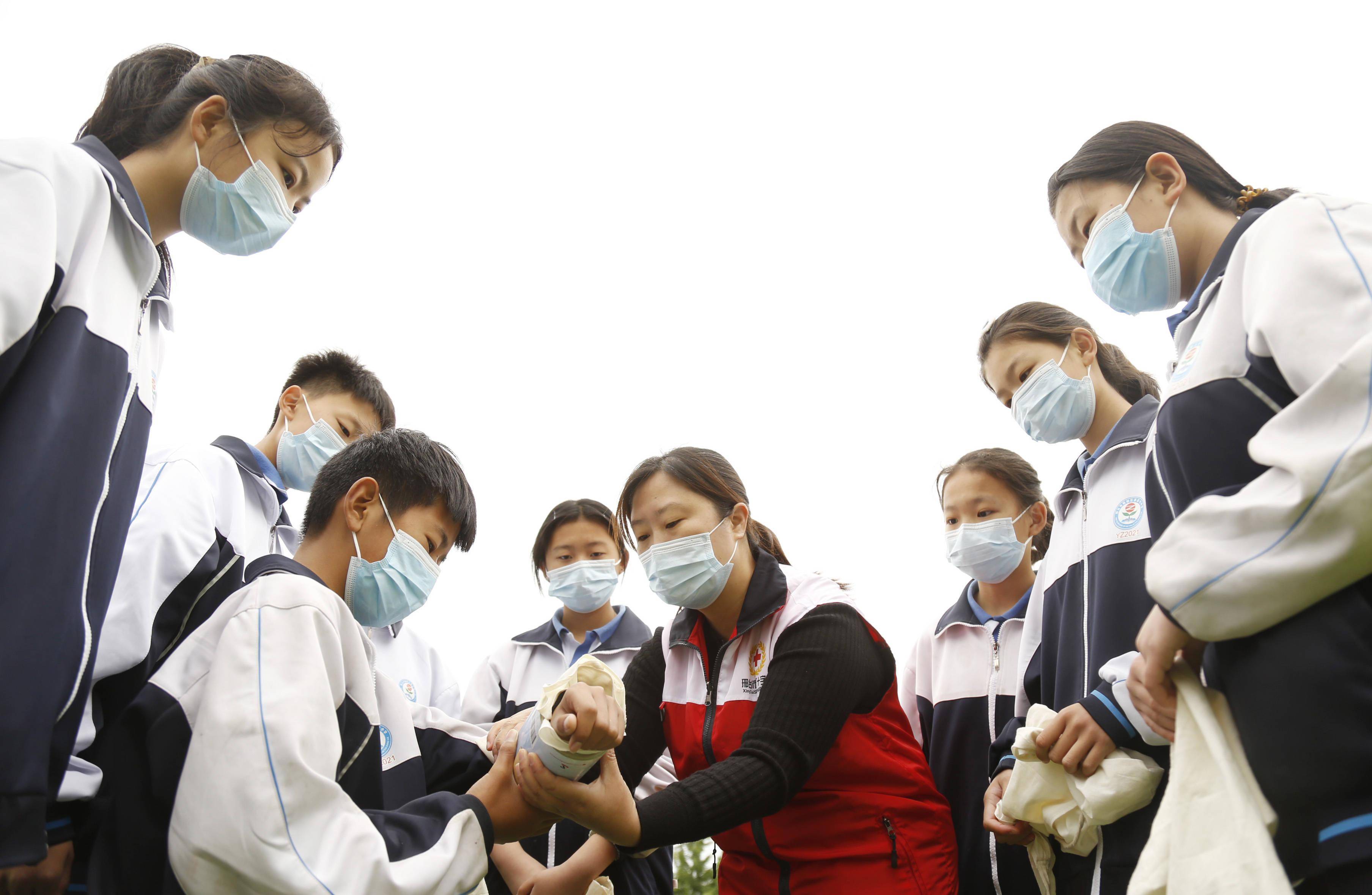 5月7日，河北省邢台市襄都区红十字会应急救护讲师在指导学生学习急救包扎。新华社发（张驰 摄）