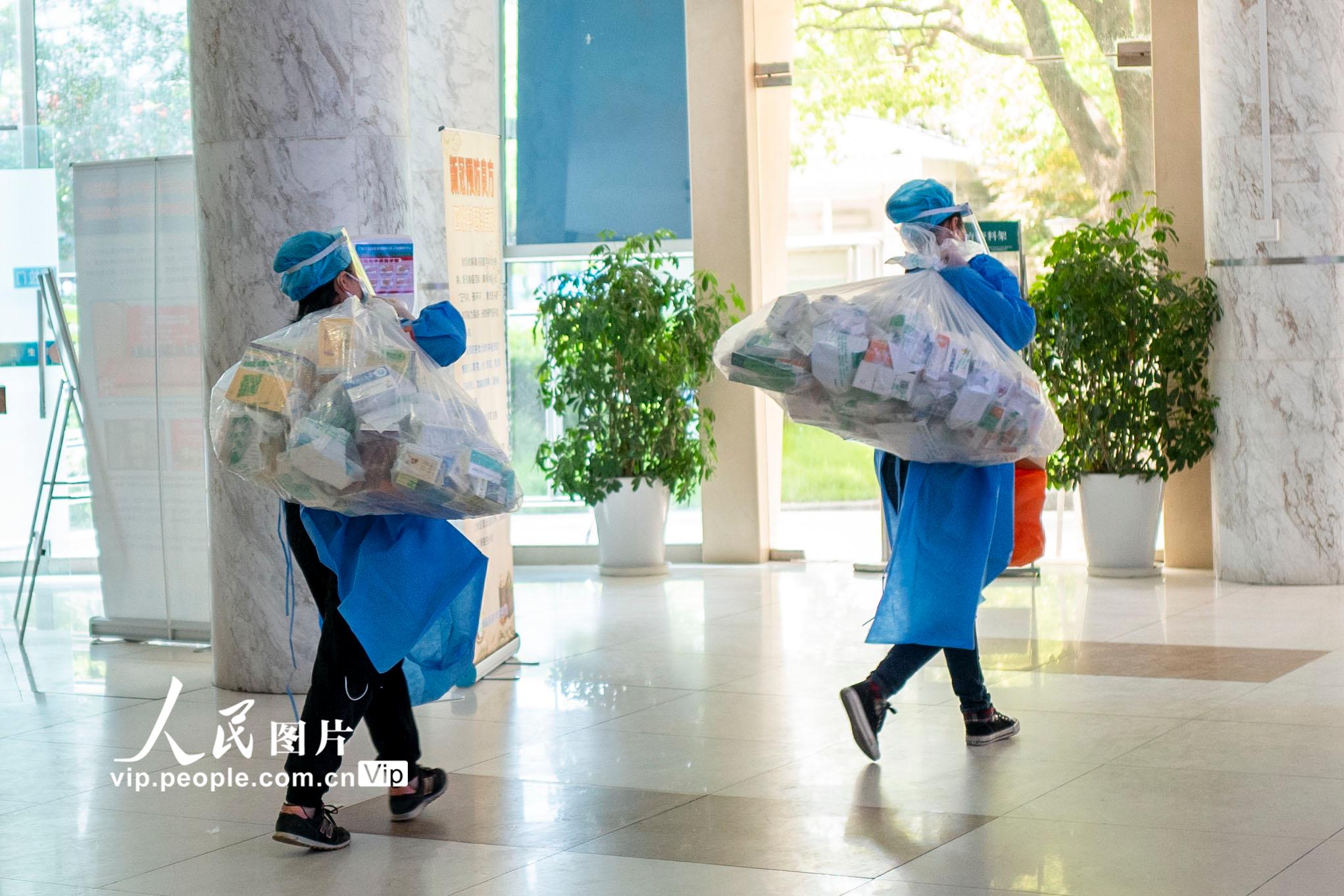 2022年5月8日，上海市寶山區淞南鎮社區衛生服務中心，來自各社區的志願者背著藥返回社區。