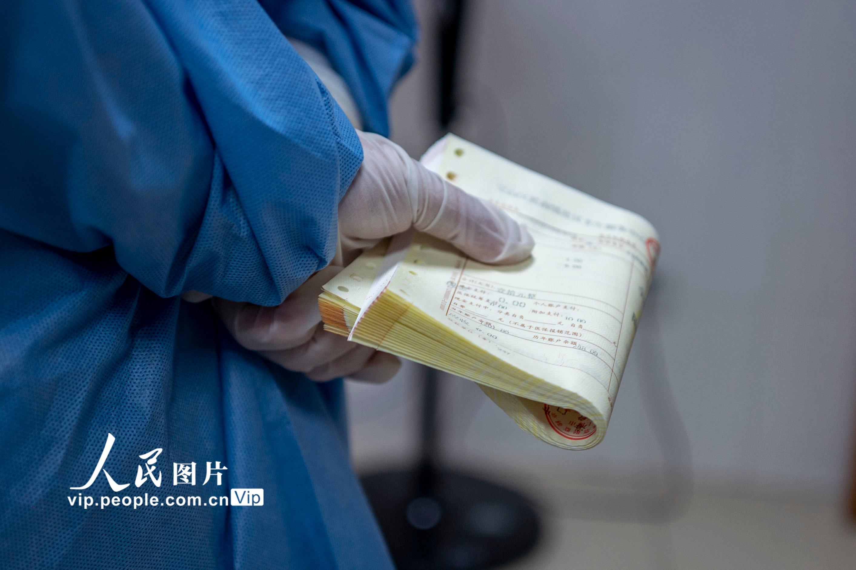 2022年5月8日，上海市寶山區淞南鎮社區衛生服務中心，社區志願者拿著挂號單等著幫居民配藥。