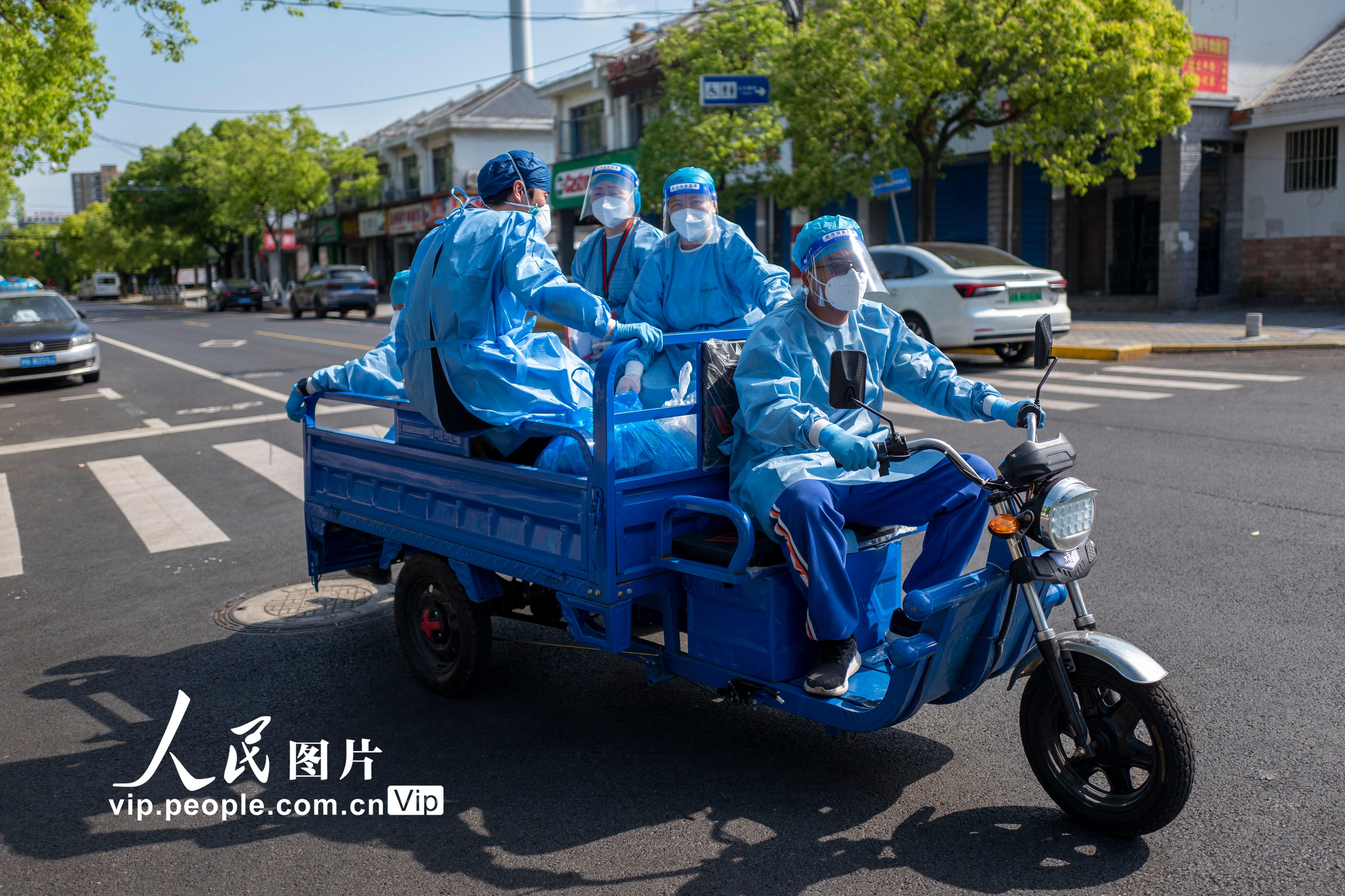 2022年5月8日，上海市寶山區淞南鎮，社區志願者們配完藥乘坐三輪車返回社區。