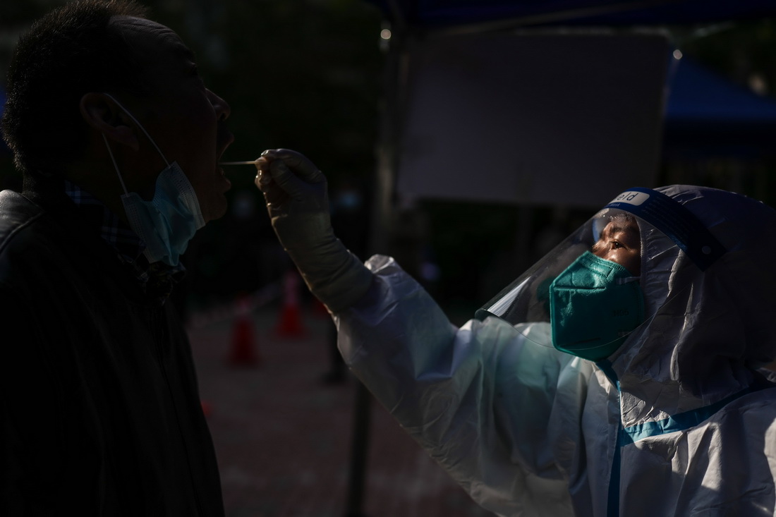 5月11日，在西城區白紙坊街道一處社區核酸採樣點，宣武醫院核酸採樣隊隊員為居民做核酸採樣。新華社記者 彭子洋 攝