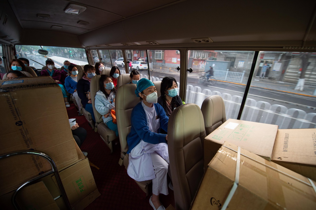 5月11日清晨，客車搭載著來自不同醫院的核酸採樣人員和物資駛向採樣點。新華社記者 陳鐘昊 攝