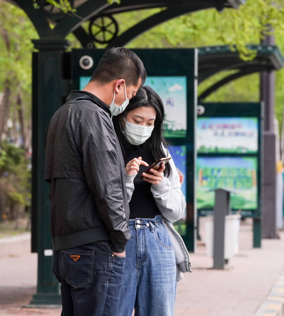 5月11日，市民在哈爾濱市一公交站台邊等待車輛。新華社記者 王鬆 攝