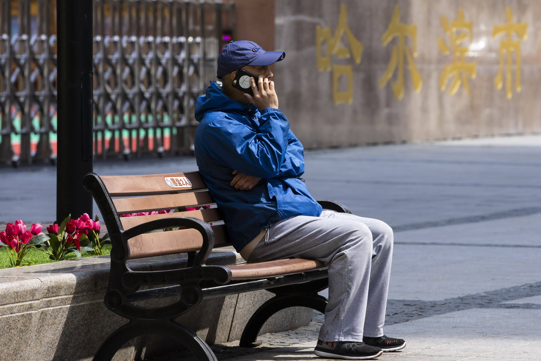 5月11日，市民在哈爾濱市道裡區中央大街上接聽電話。新華社記者 張濤 攝