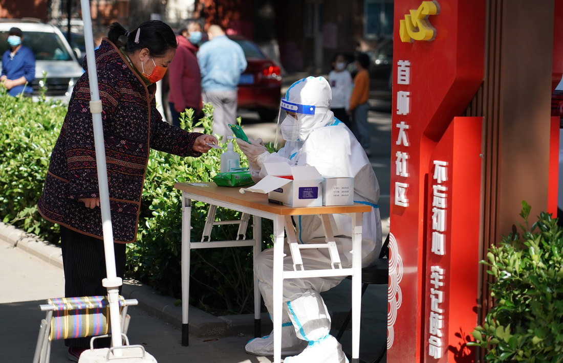 5月13日，在北京市海澱區八裡庄街道首師大社區的一處臨時核酸檢測採樣點，工作人員登記市民信息。