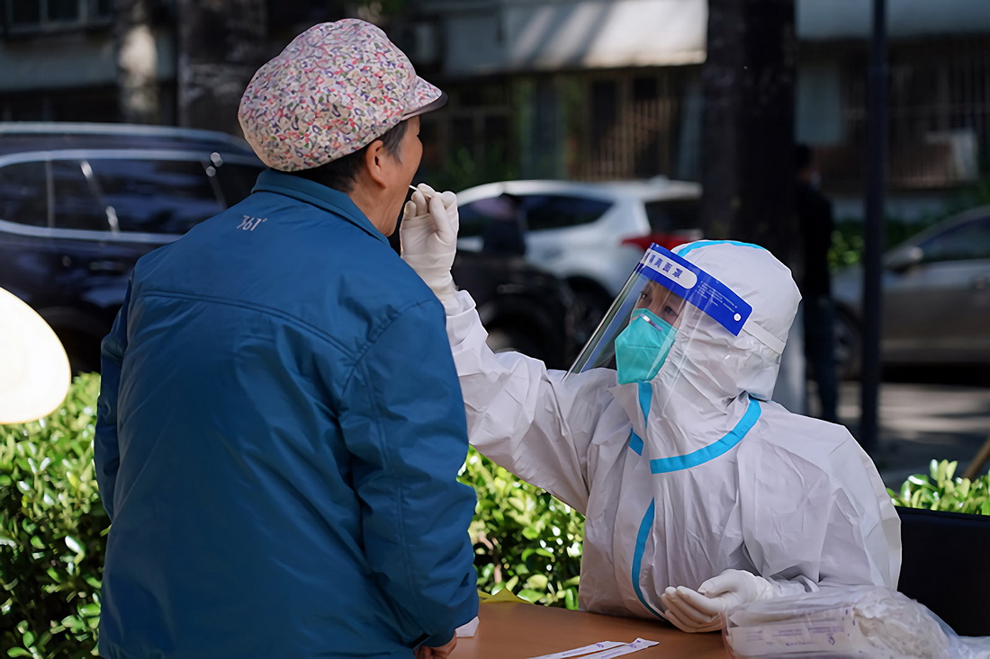 5月13日，在北京市海澱區八裡庄街道首師大社區的一處臨時核酸檢測採樣點，醫護人員進行核酸採樣。