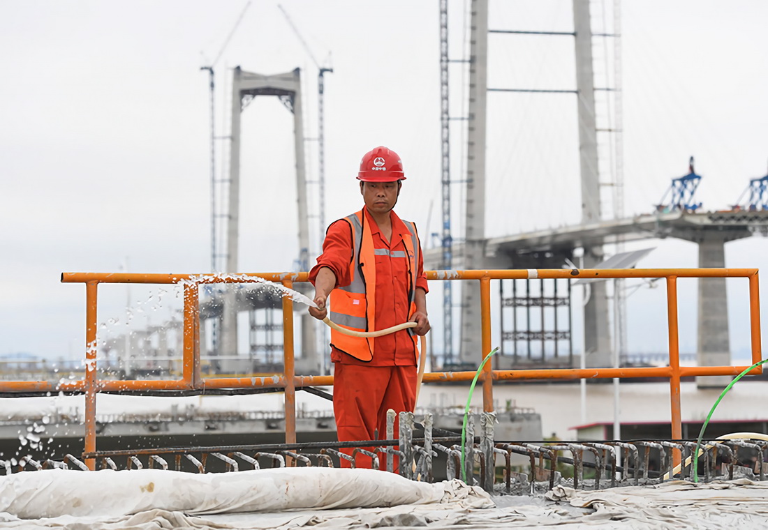 5月15日，工人對澆筑完成的深中通道第100片60米混凝土箱梁進行養護。