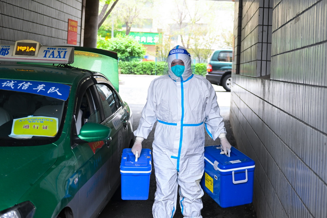 5月14日，王振民在青海省西寧市城西區一處社區搬運核酸檢測樣本箱。新華社記者 張龍 攝