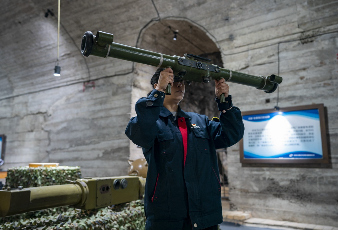 5月16日，一名工作人员在中国光学历史博物馆内展示对空测距机使用方法。