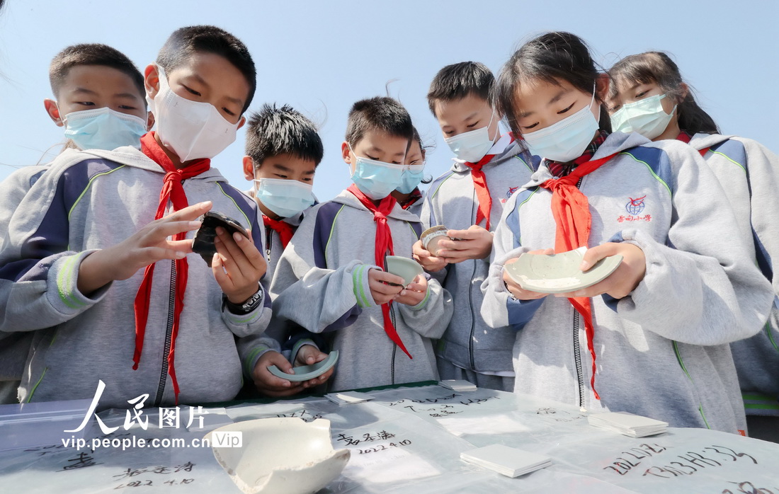 2022年5月17日，浙江省湖州市德清县雷甸镇中心小学的学生在中初鸣制玉作坊遗址群观看出土的瓷器。