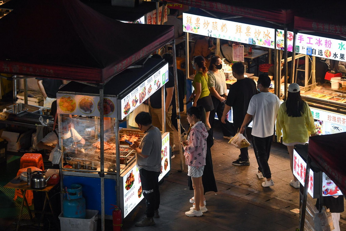 5月17日，居民在濮院鎮佳源夜市的小吃攤挑選美食。 