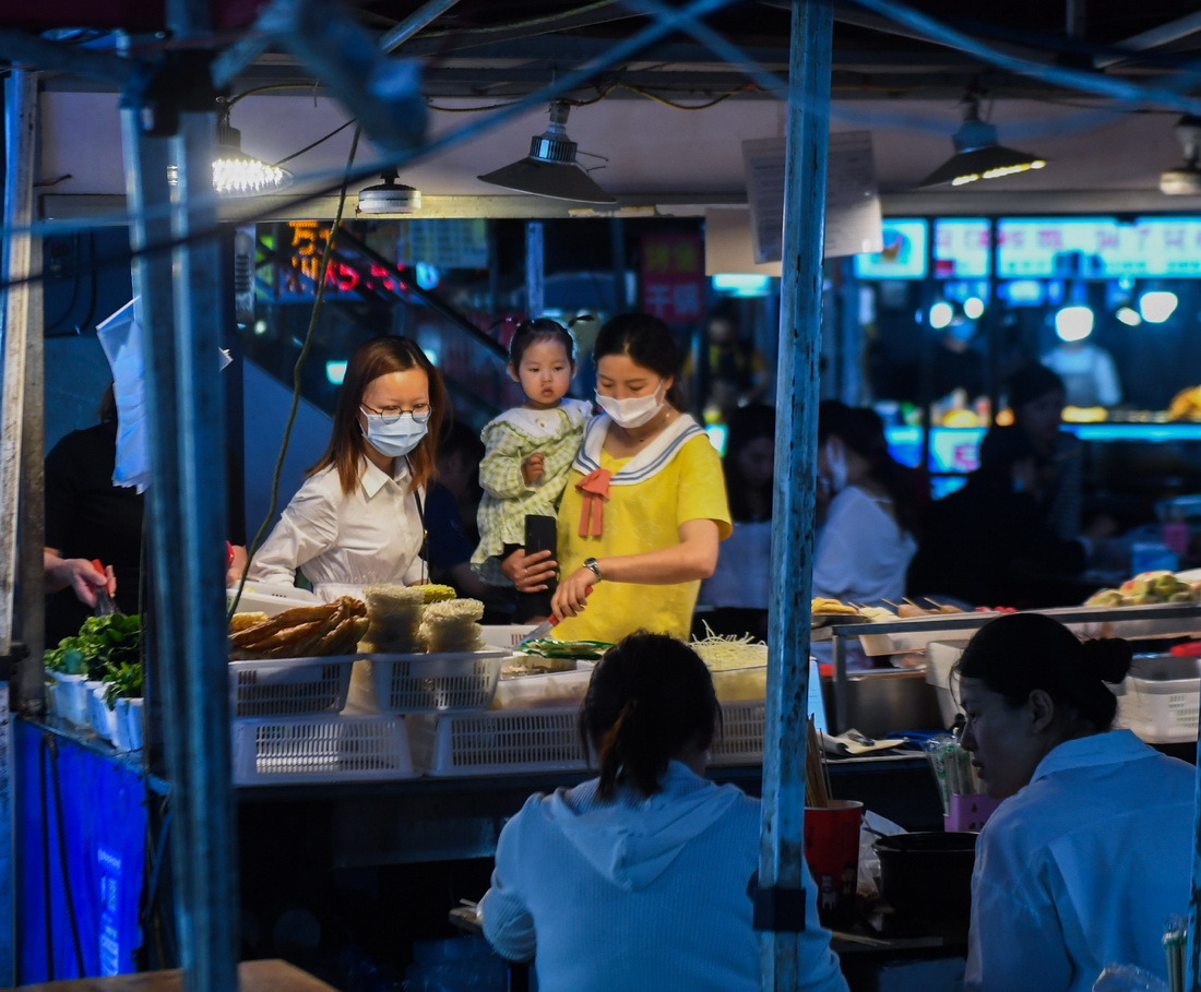 5月17日，居民在濮院鎮佳源夜市的小吃攤挑選美食。 