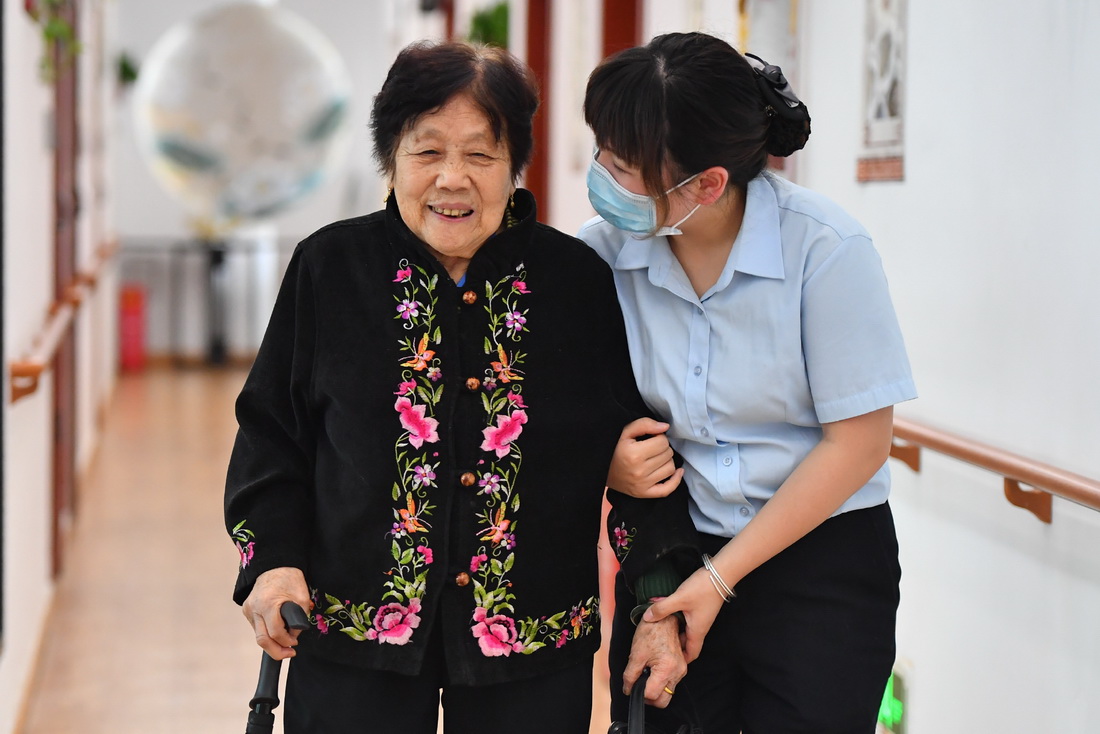 在湘潭市雨湖区窑湾街道综合养老服务中心，刘梦搀扶腿脚不便的老人行走（5月17日摄）。