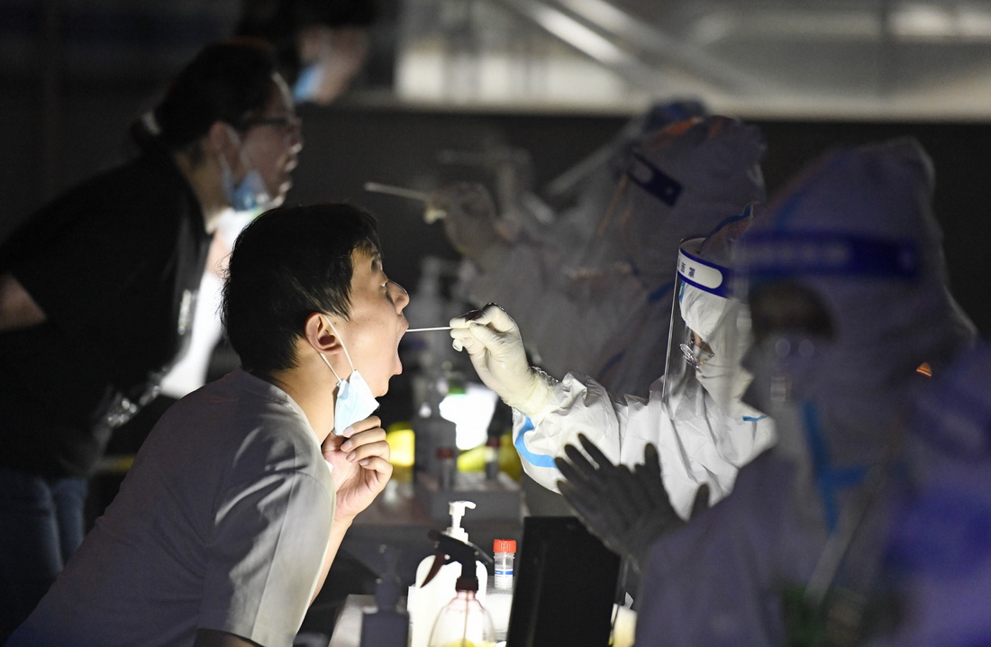 5月20日，在天津市南開區一處核酸檢測點，醫務人員為社區居民做核酸採樣。新華社記者 趙子碩 攝