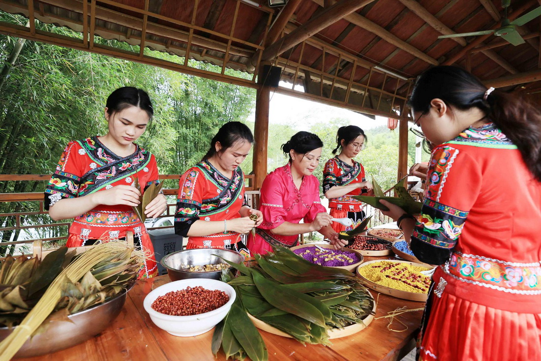 5月25日，在廣西融安縣雅瑤鄉章口村，村民在制作五彩粽子。新華社發（譚克興 攝）