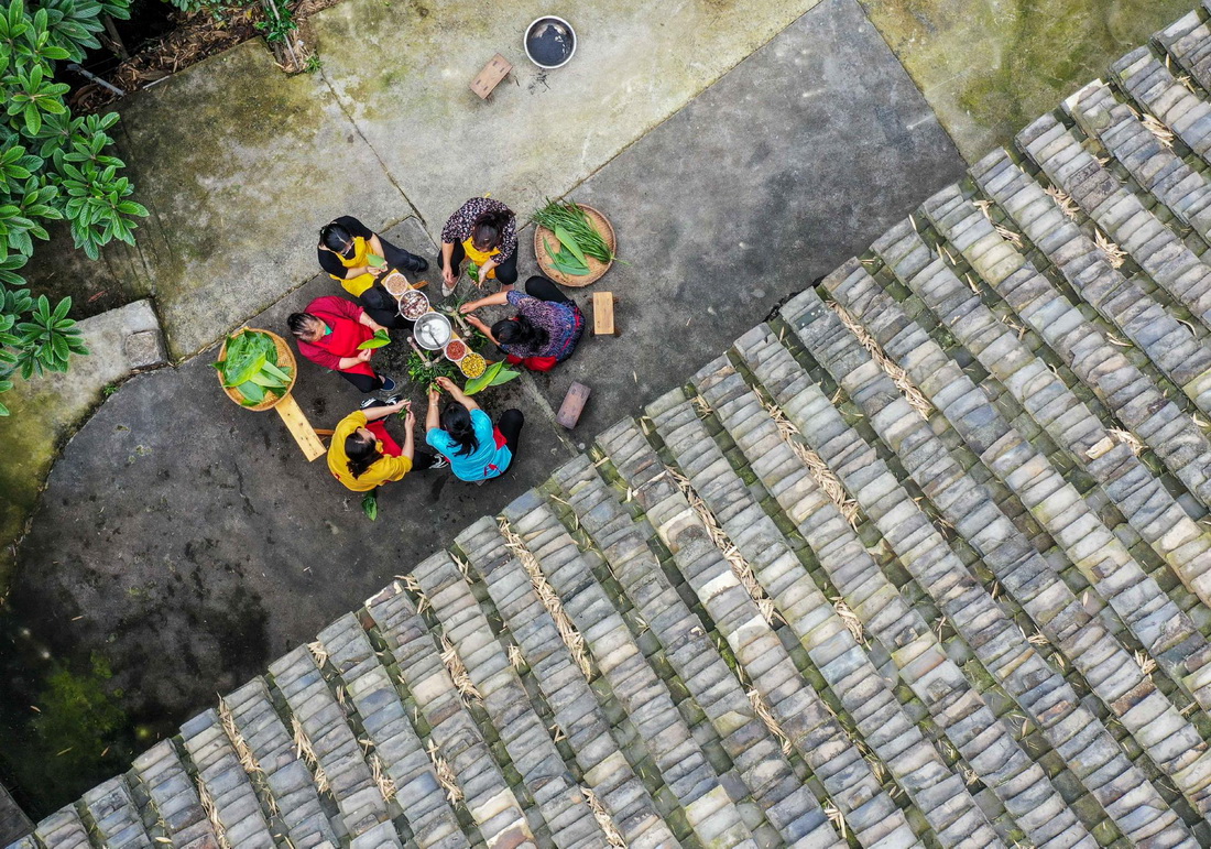 5月25日，村民在貴州省岑鞏縣思旸鎮龍江村包粽子（無人機照片）。新華社發（胡攀學 攝）