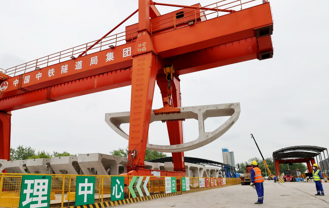 5月28日，在中铁隧道局机场联络线11标段施工现场，工人操作龙门吊将运到施工现场的弧形件吊起。