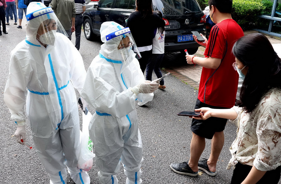 5月30日，上海市普陀區一居民小區的居民進行核酸採樣前的掃碼登記。