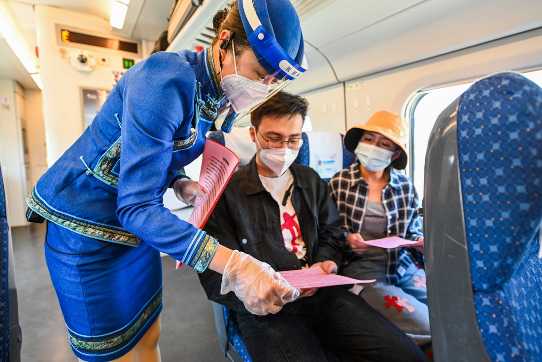 5月30日，乘务员在列车上向旅客讲解禁烟知识。