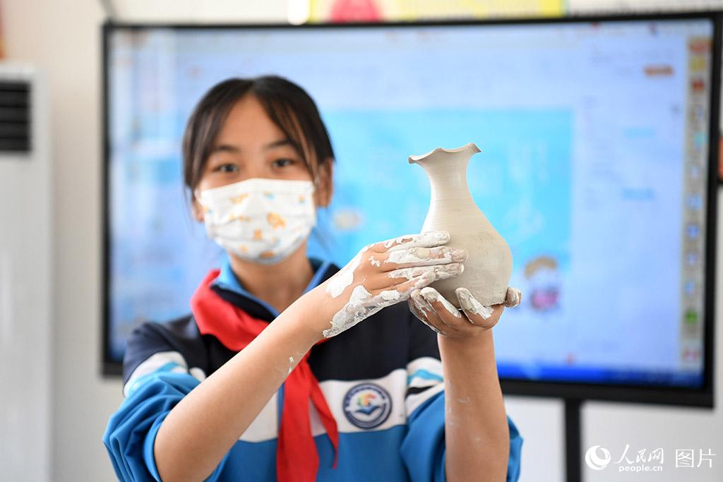 5月31日，河北省定州市清水河小學學生展示新制作的定瓷拉坯作品。人民網 周博攝