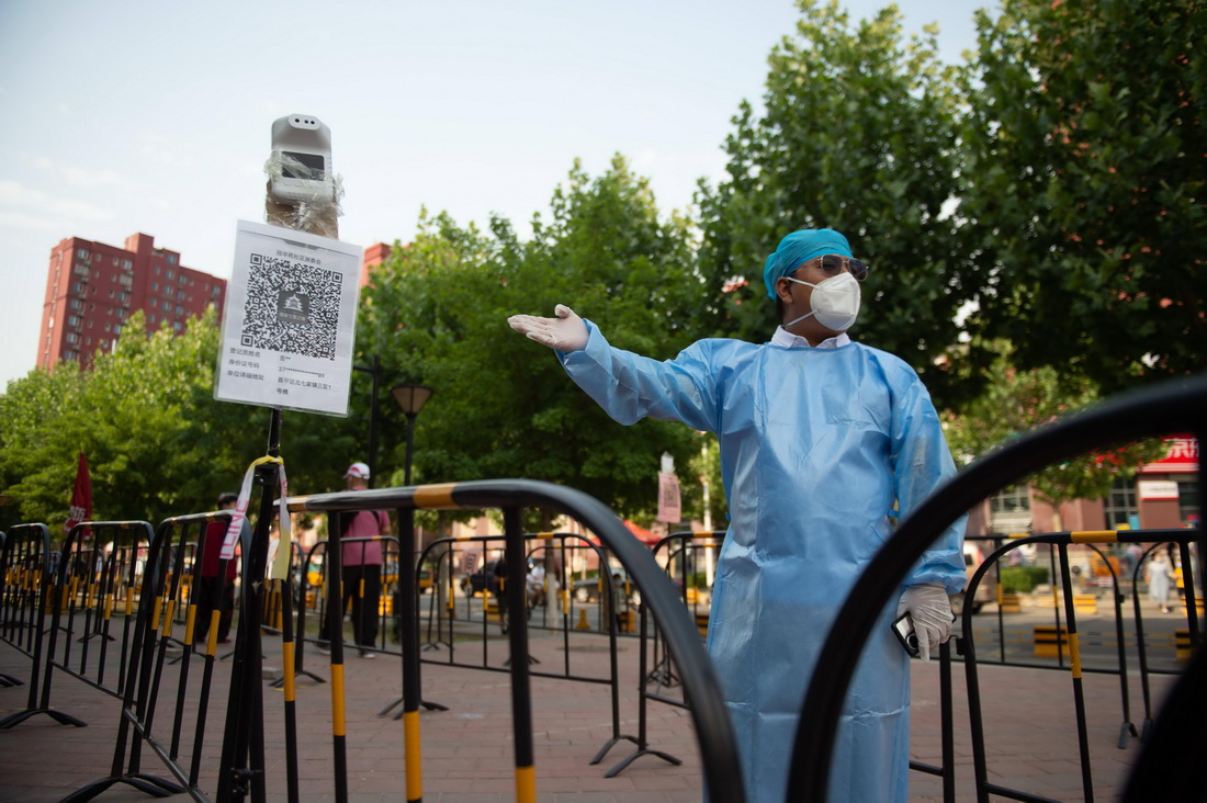 6月3日，張旭引導前來進行核酸採樣的居民掃描北京健康寶。新華社記者 陳鐘昊 攝