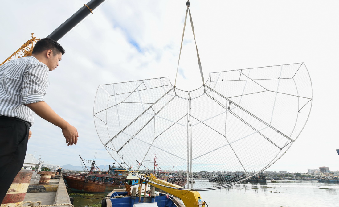 2020年11月18日，在海南省三亞市崖州中心漁港，吳川良指揮吊車將大型類礁人工苗圃起吊裝船。