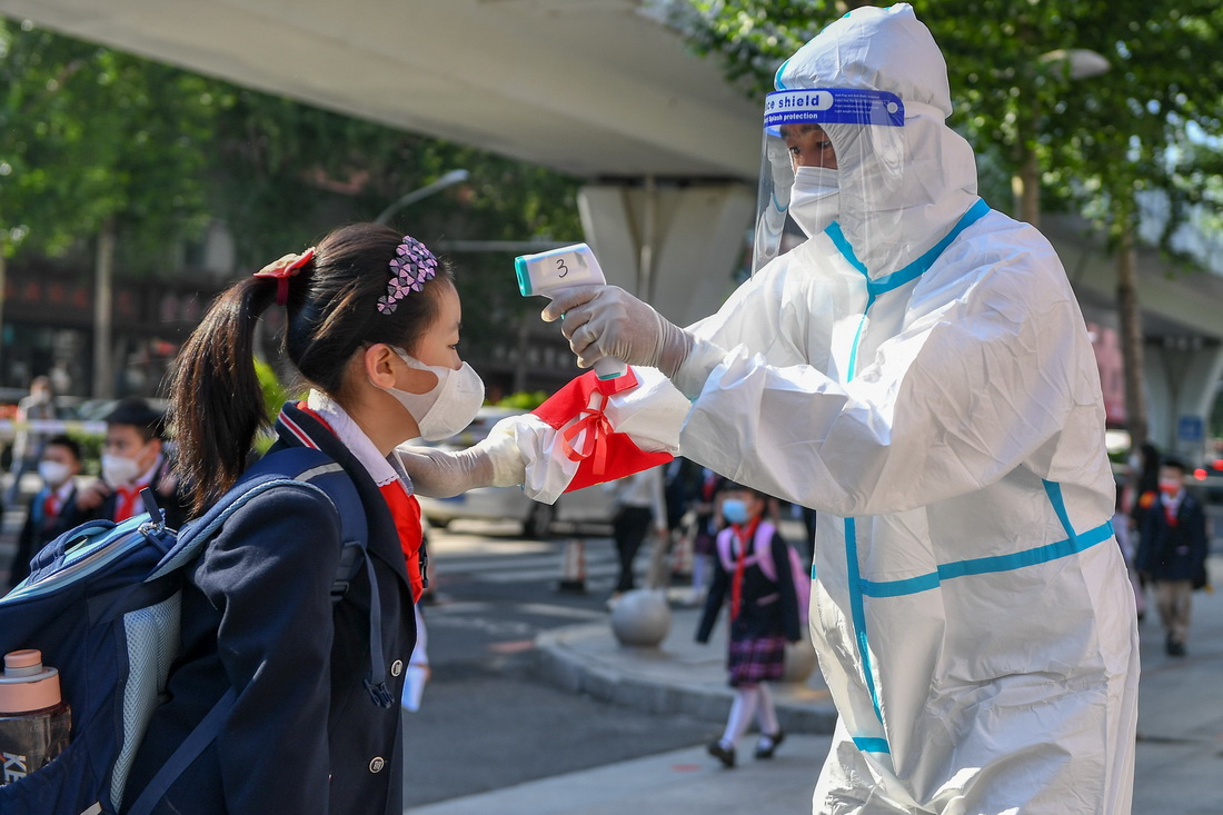 6月10日，在长春市赫行实验学校小学部，工作人员为学生测温。