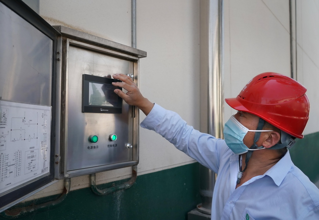 工作人员在中央储备粮鹤壁直属库有限公司浚县分公司内调试内环流均温控制系统（6月10日摄）。