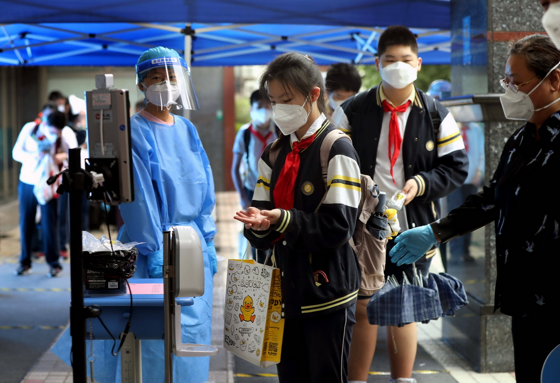6月13日，上海市格致初级中学的初三学生在入校时进行手部消毒。