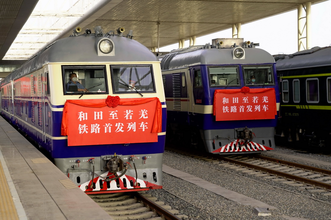 6月16日，和若铁路首趟旅客列车（左）和货运列车在新疆和田火车站等待发车。