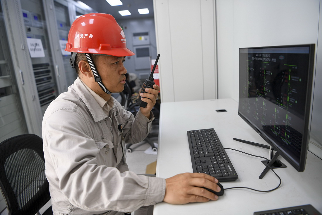 工作人員在國家能源集團寧夏電力公司寧東電廠3×5.98兆瓦漂浮分布式光伏發電項目控制室進行設備調試（6月17日攝）。