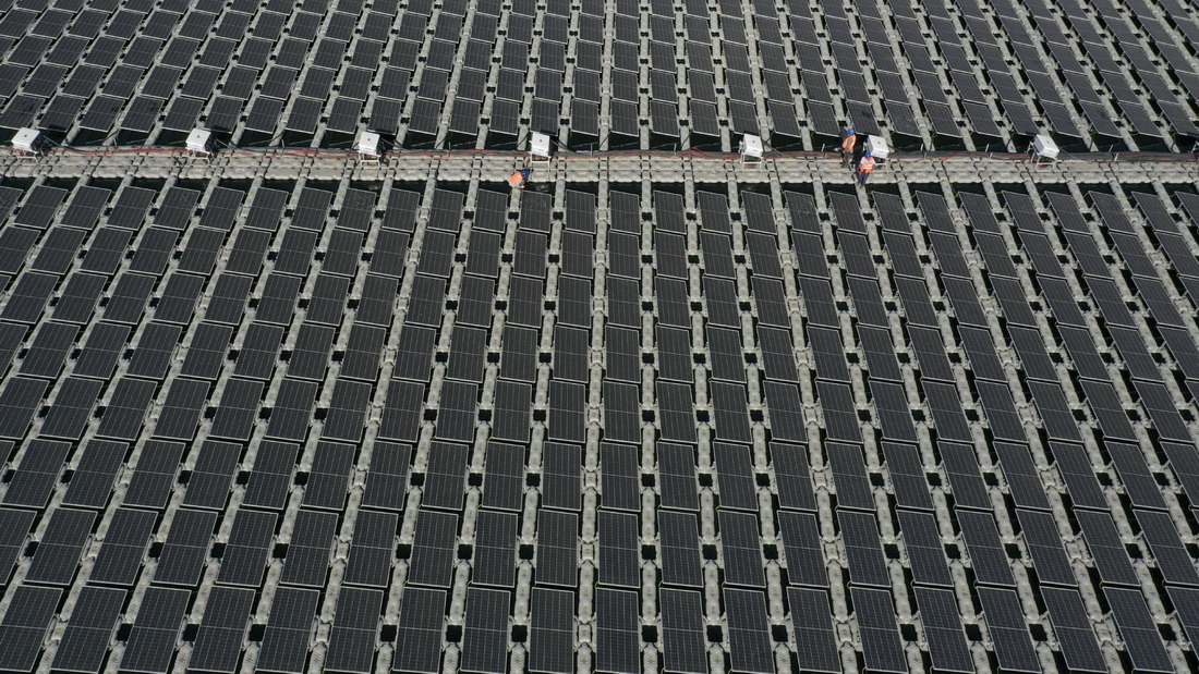 工人在國家能源集團寧夏電力公司寧東電廠3×5.98兆瓦漂浮分布式光伏發電項目現場施工（無人機照片，6月17日攝）。