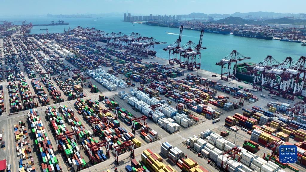 繁忙的山东港口青岛港前湾港区，集装箱货轮在装卸集装箱（6月15日摄，无人机照片）。