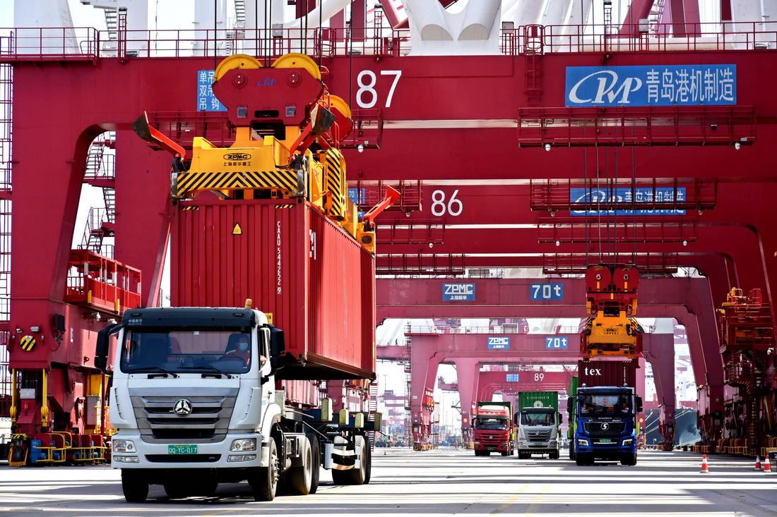 山东港口青岛港前湾港区，集装箱被吊上货轮（6月15日摄）。
