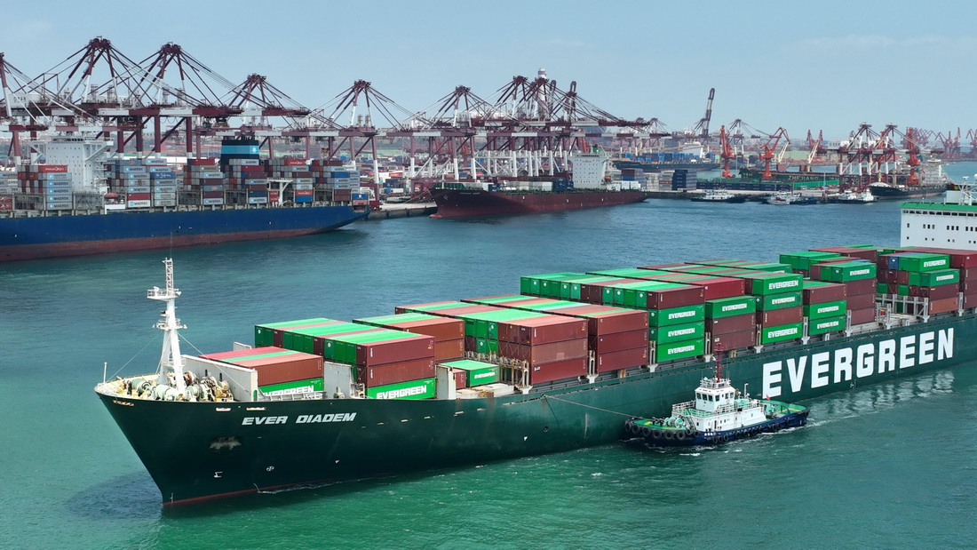 山东港口青岛港前湾港区，一艘集装箱货轮正进港靠泊码头（6月15日摄，无人机照片）。