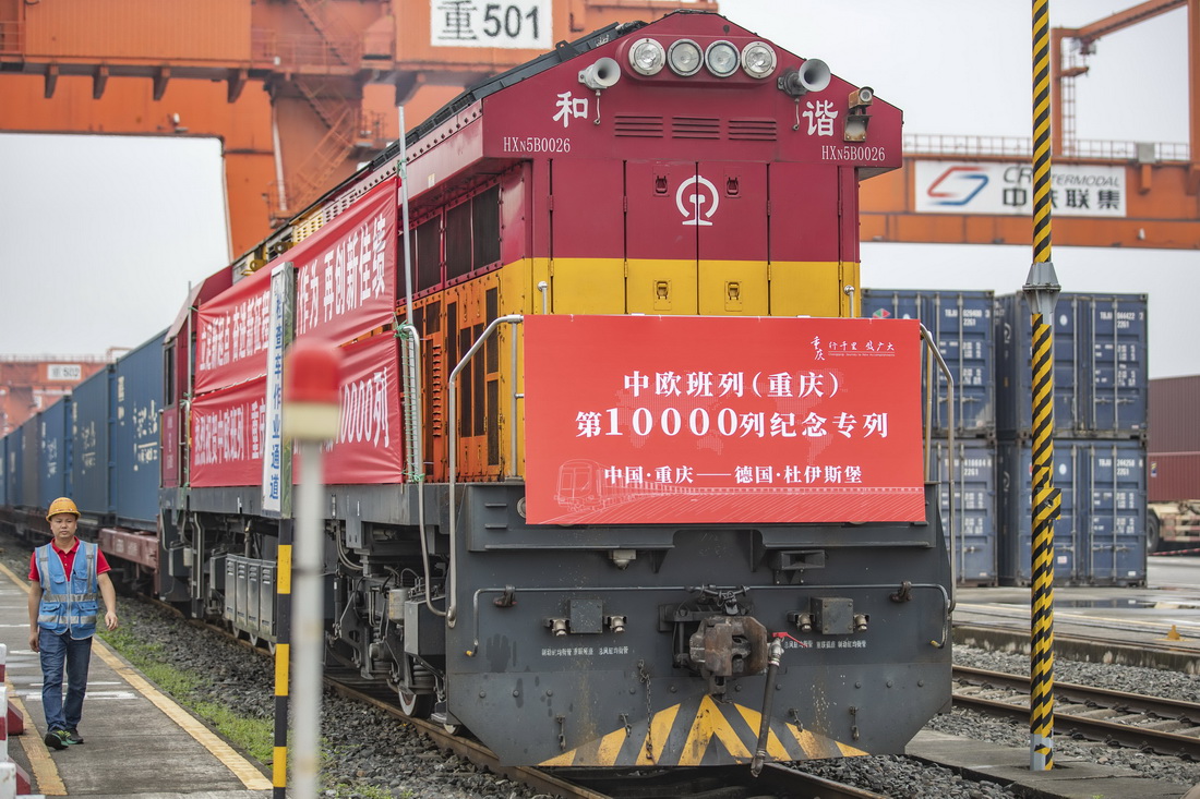 6月23日，在重庆团结村中心站，铁路工作人员从中欧班列（重庆）第10000列列车旁走过。